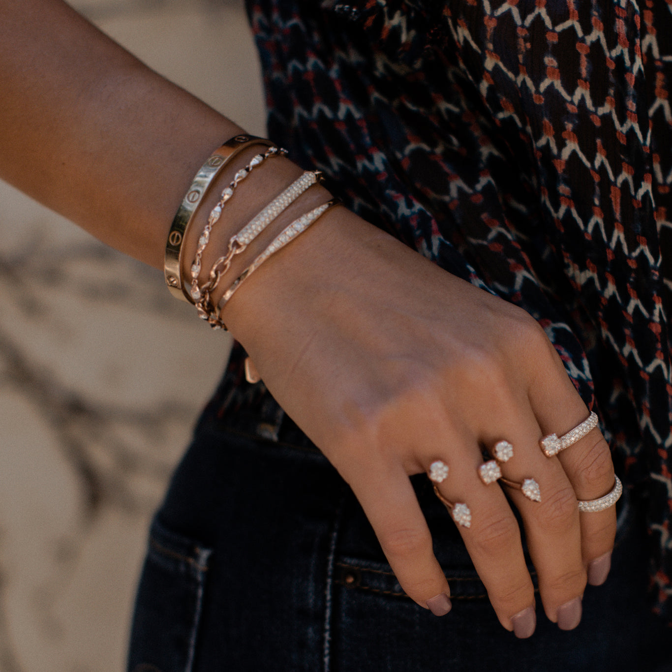 The Marquise Bangle, Amalfi Bracelet, and Pantheon Bracelet shown stacked together. On the hand, the model is wearing Throne Rings and an Olympus Ring.