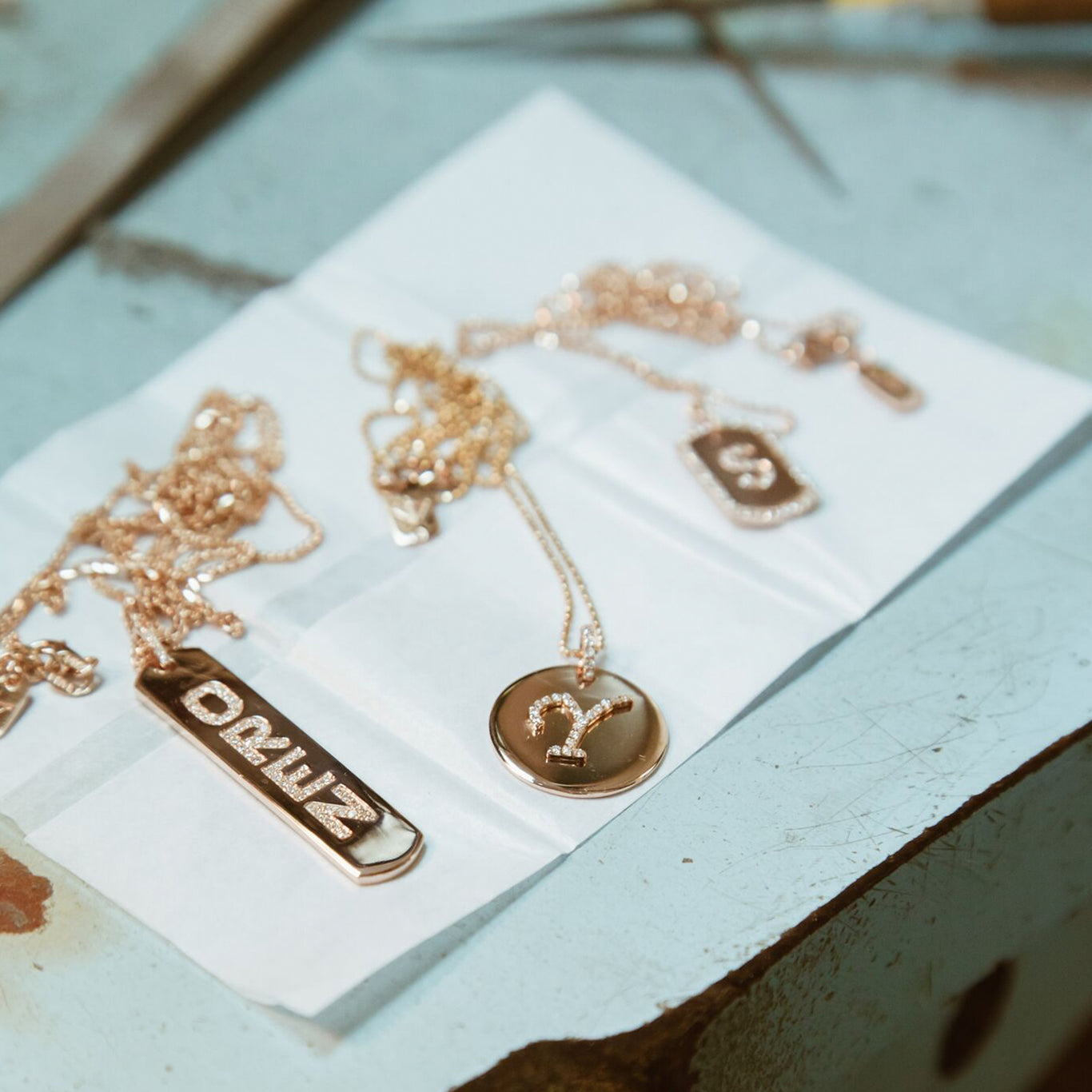The Renata Necklace shown behind the scenes in production with the Longtag Necklace and Initial Dogtag. All three necklaces are part of our Monogram Collection.