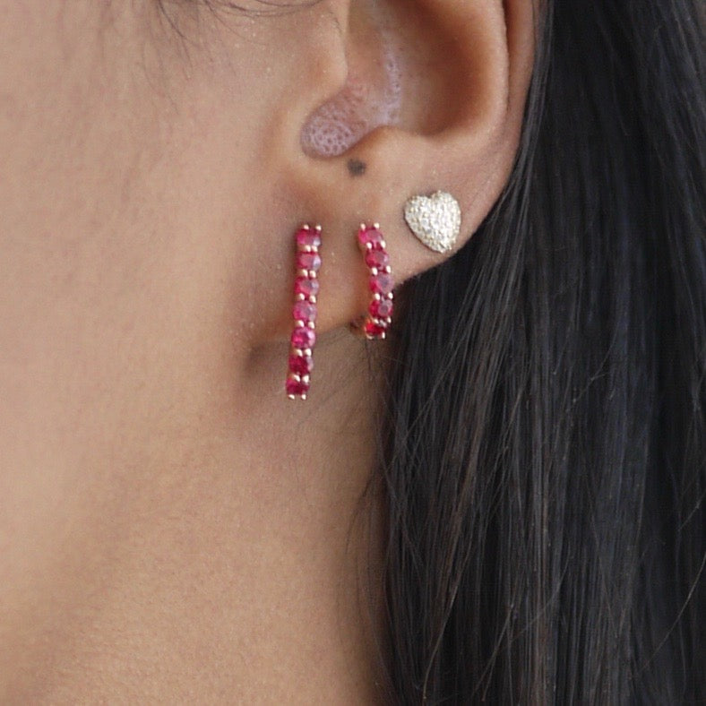 Ruby Sparkler Huggies shown in rose gold next to the Ruby Sparkler Pin Earrings.