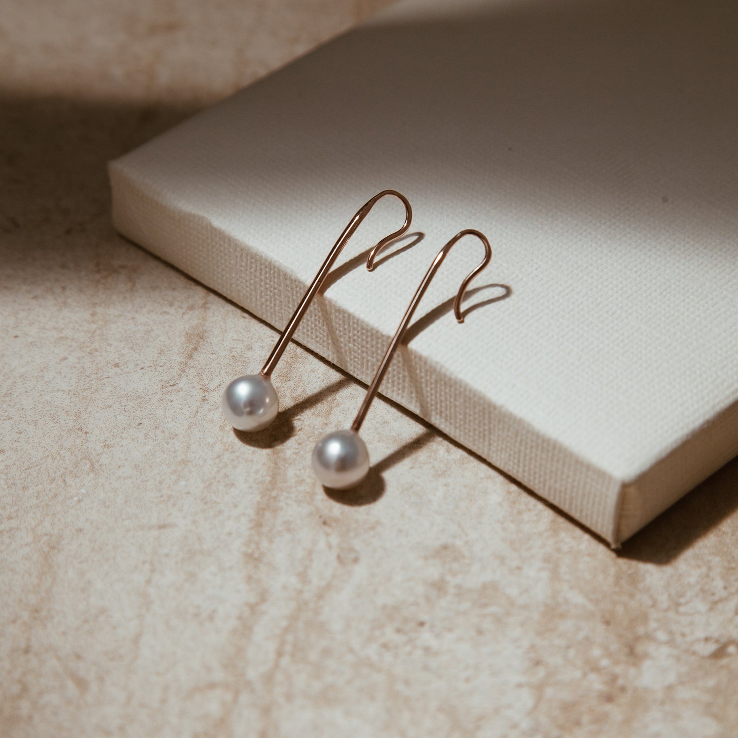 The Pearl Stick Earrings shown in rose gold.