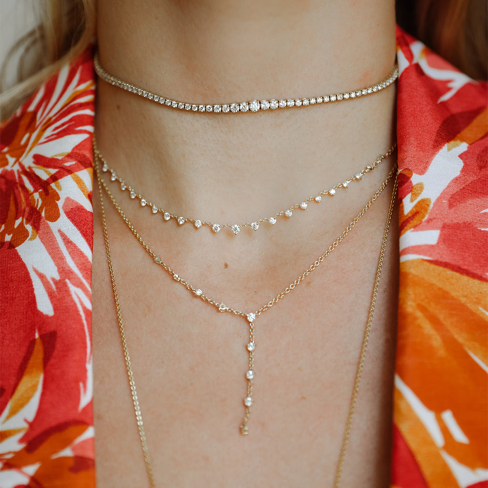 The Starstruck Necklace shown in yellow gold layered with the 3.50ct Graduated Tennis Choker and the Sparkler Lariat