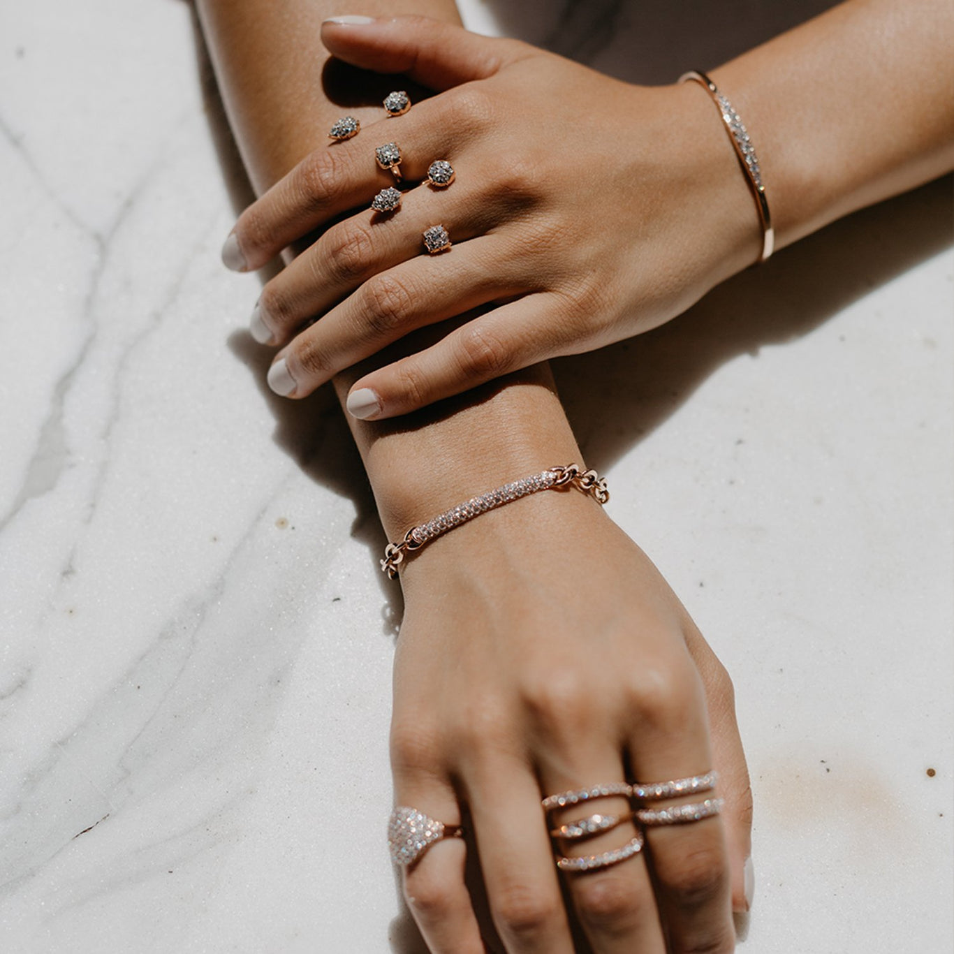 The Pantheon Bracelet shown in Rose Gold next to the Throne Rings on the Left hand.