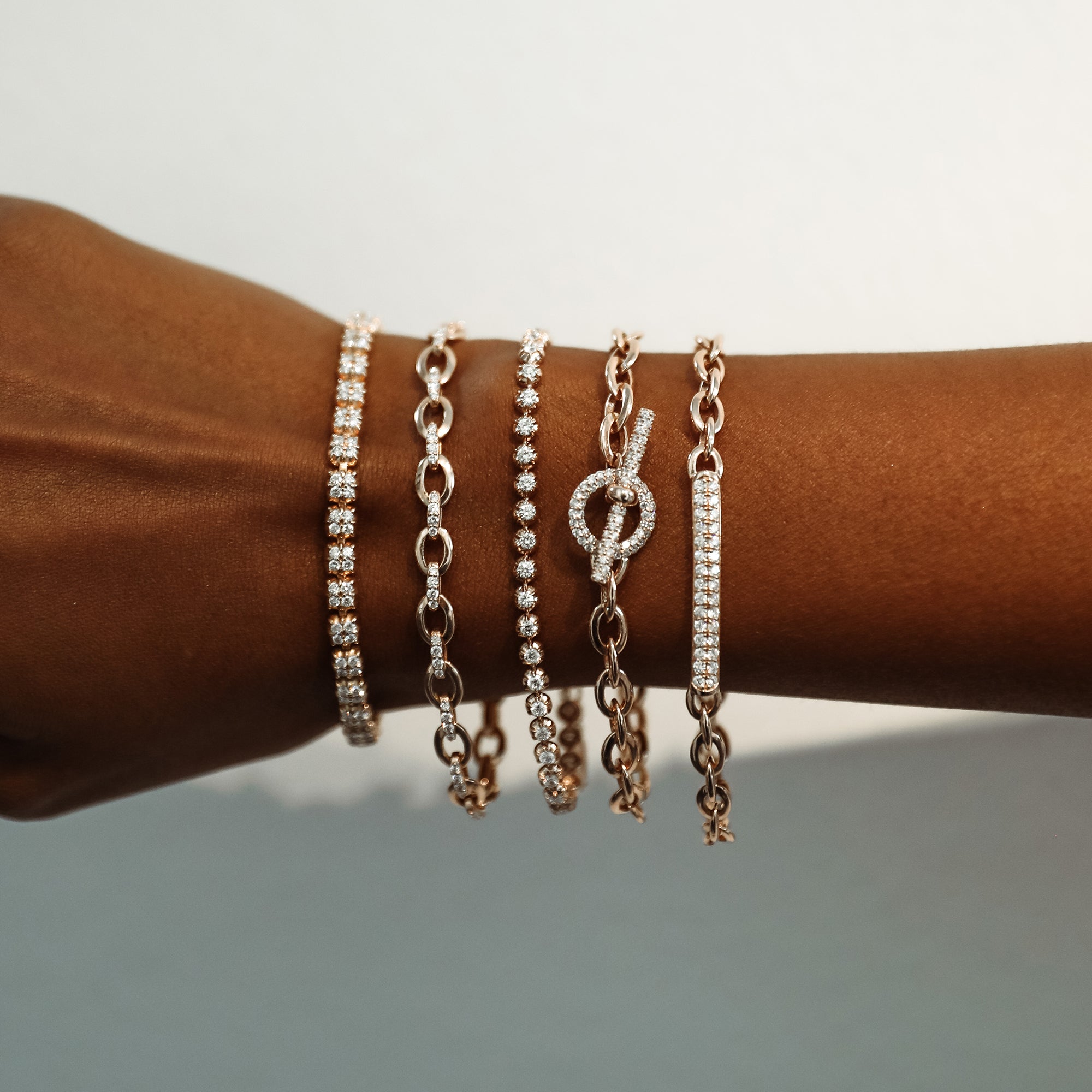 The Oval Link Bracelet shown stacked with the Trilogy Bracelet, Rosette Bracelet, Big Link Bracelet, and Mini Pantheon Bracelet. 
